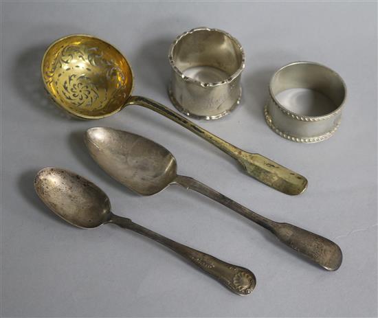 A late 18th/early 19th century French silver gilt sifter spoon, two later silver spoons and two silver napkin rings.